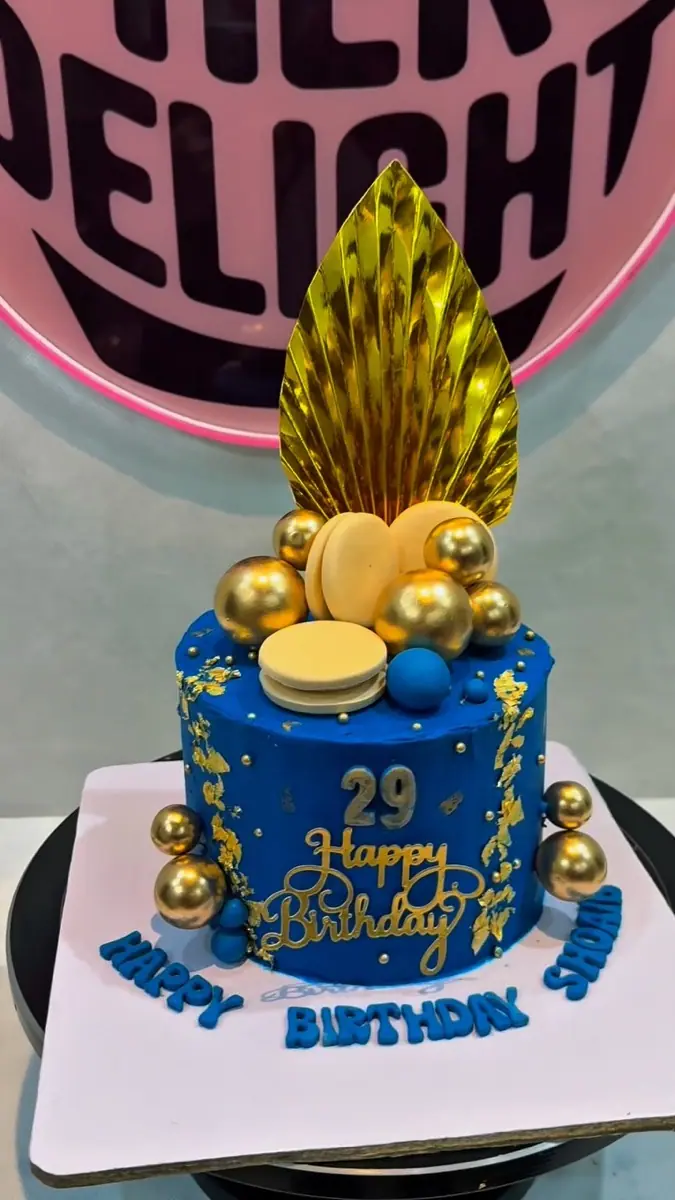 Blue and gold birthday cake with gold leaf and spheres