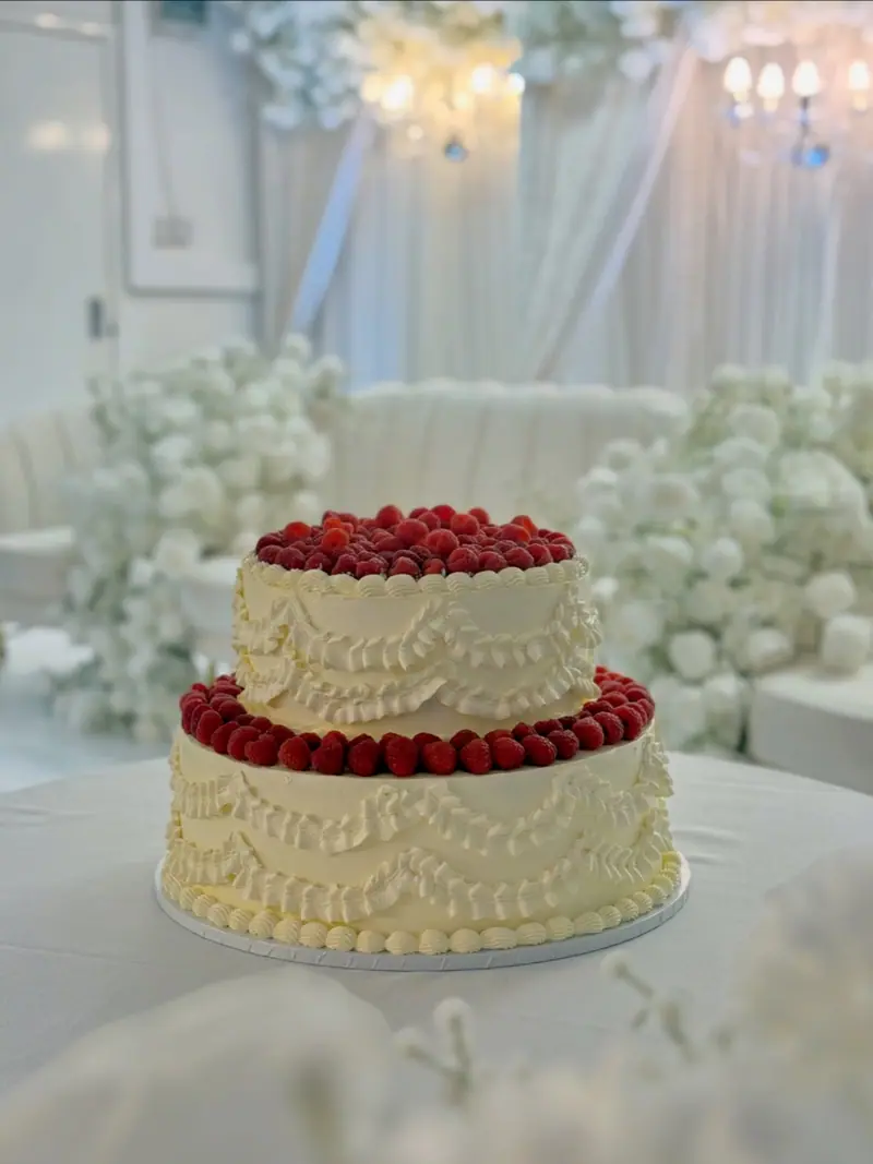 Two-tier wedding cake with fresh raspberries